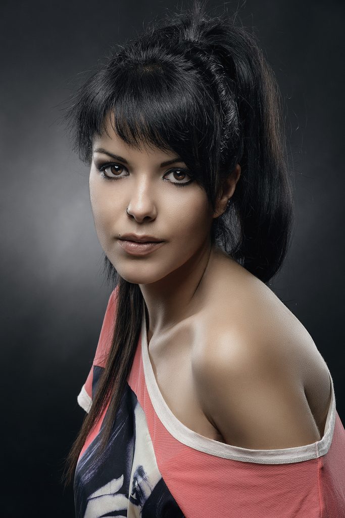 Sesión de estudio de modelo con camiseta roja enseñando un hombro, fotografía de Rubén Casado