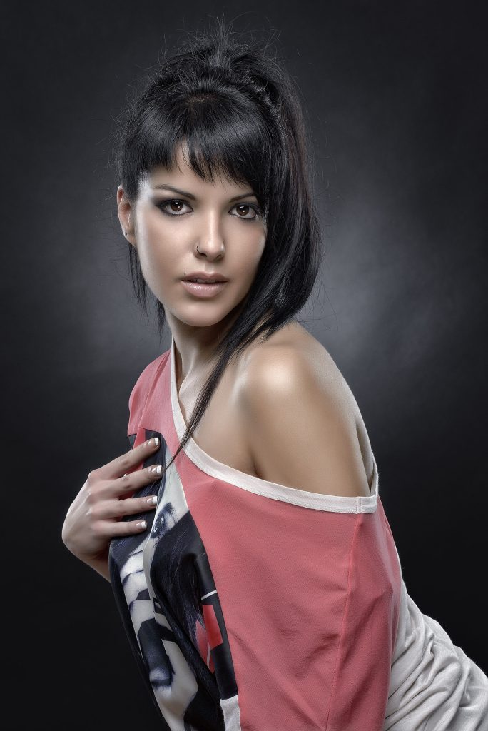 Sesión de estudio de modelo con camiseta roja enseñando un hombro, fotografía de Rubén Casado