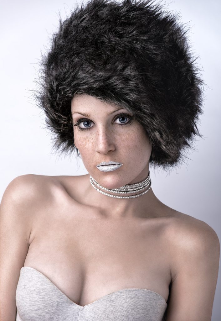 Sesión fotográfica de estudio de modelo con gorro de pelo y aros en el cuello, fotografía de Rubén Casado