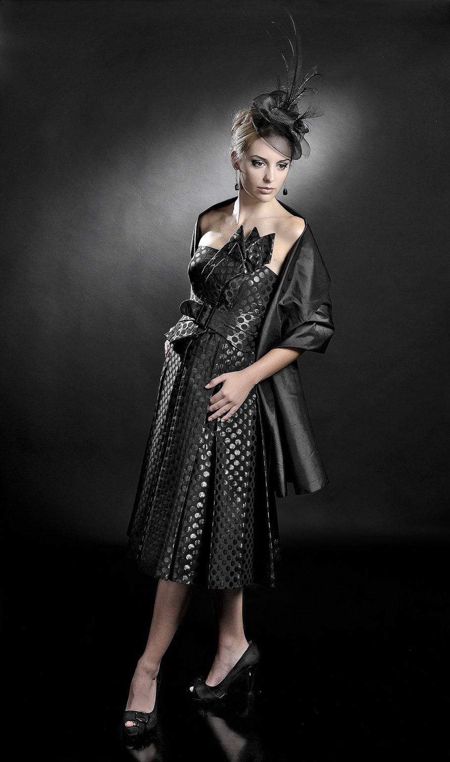 Modelo femenina con vestido negro de noche y tocado con plumas, diseño de Antonio aguado y foto de Rubén Casado en Valladolid