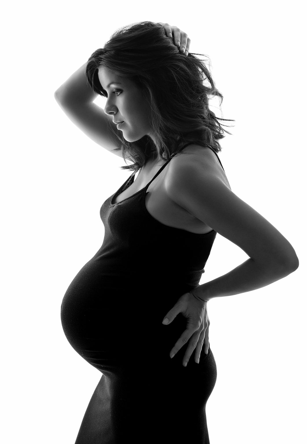 Modelo con vestido negro largo embarazada en estudio por Rubén Casado.