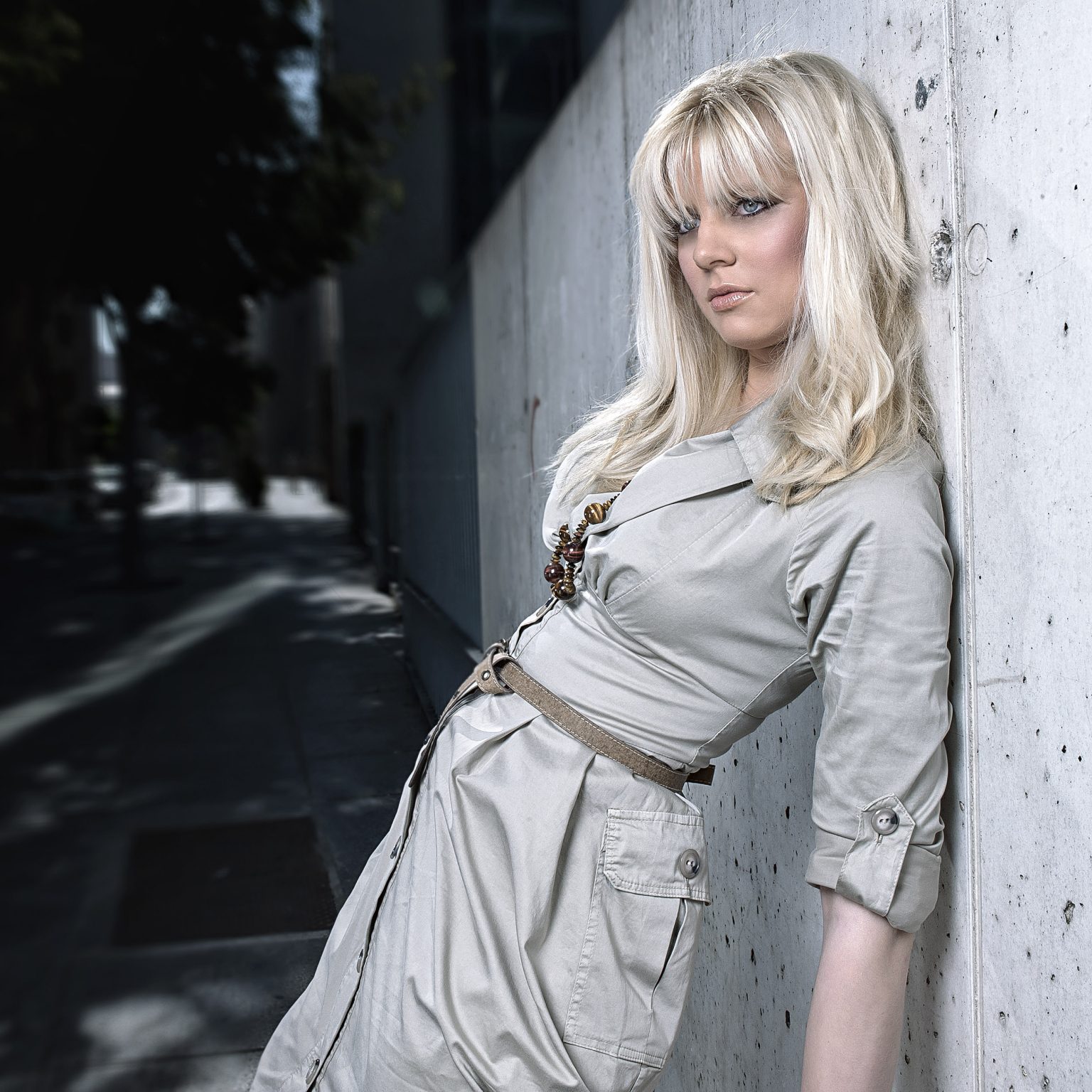 Modelo rubia apoyada en la pared con vestido en color crudo. Editorial de moda en exteriores - Rubén Casado Valladolid